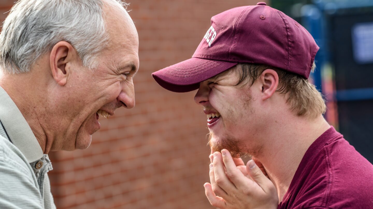 special needs young person smiling with elderly man