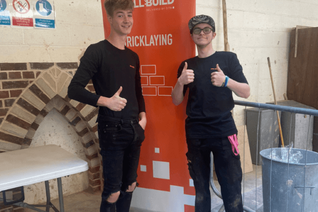 Two bricklaying students giving thumbs up